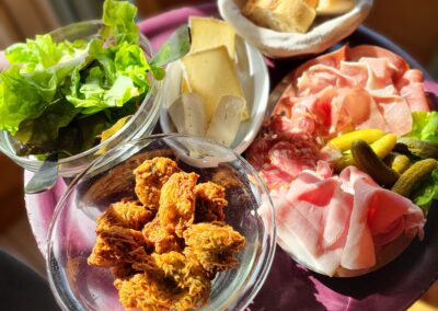 Plateau avec salade charcuterie fromages et beignets de pomme de terre de La Ferme restaurant col de la forclaz