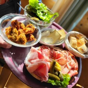 plateau avec charcuterie salade, fromages et beignets de la ferme restaurant col de la Forclaz
